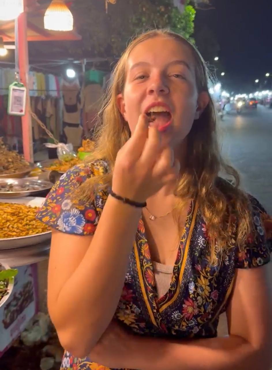 Abbey trying insects at the night market